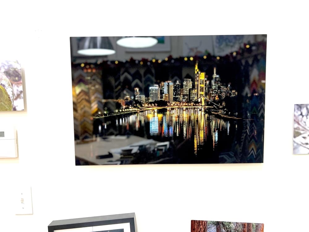 photo print of a city at night reflecting on water below it