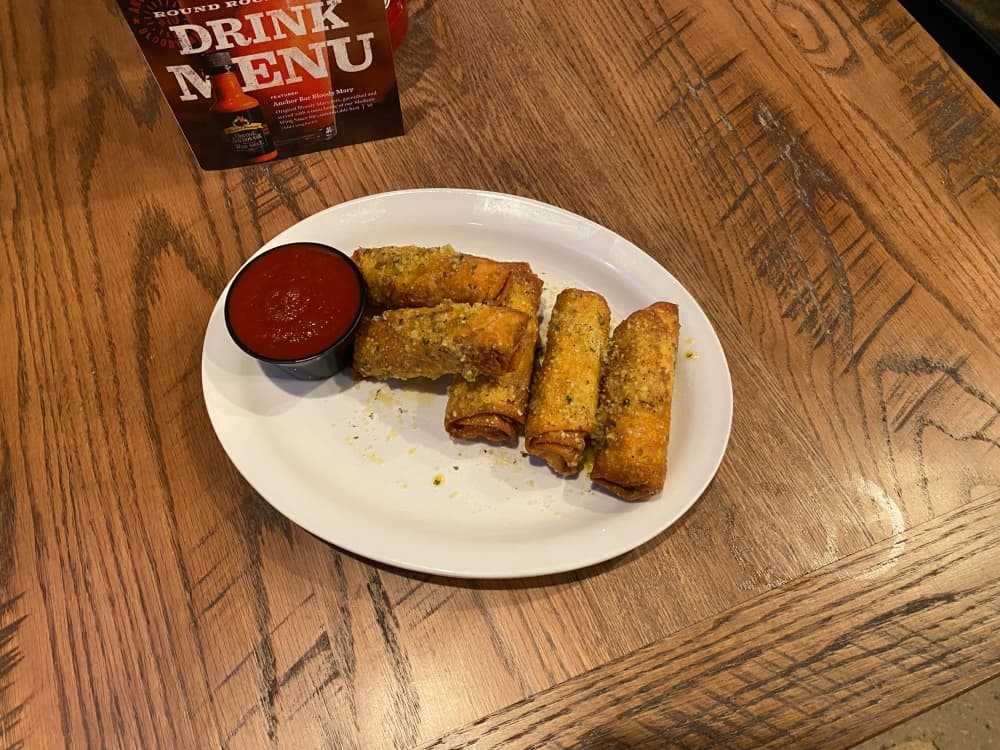 pizza logs on plate with marinara sauce on the side