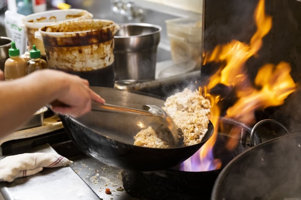 rice being made in skillet over open fire 