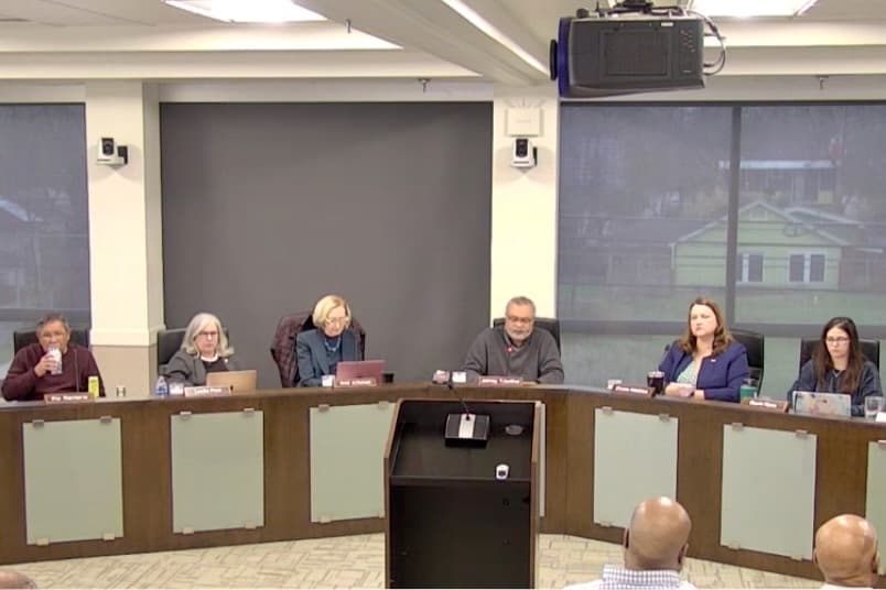 Six people sitting behind a dias