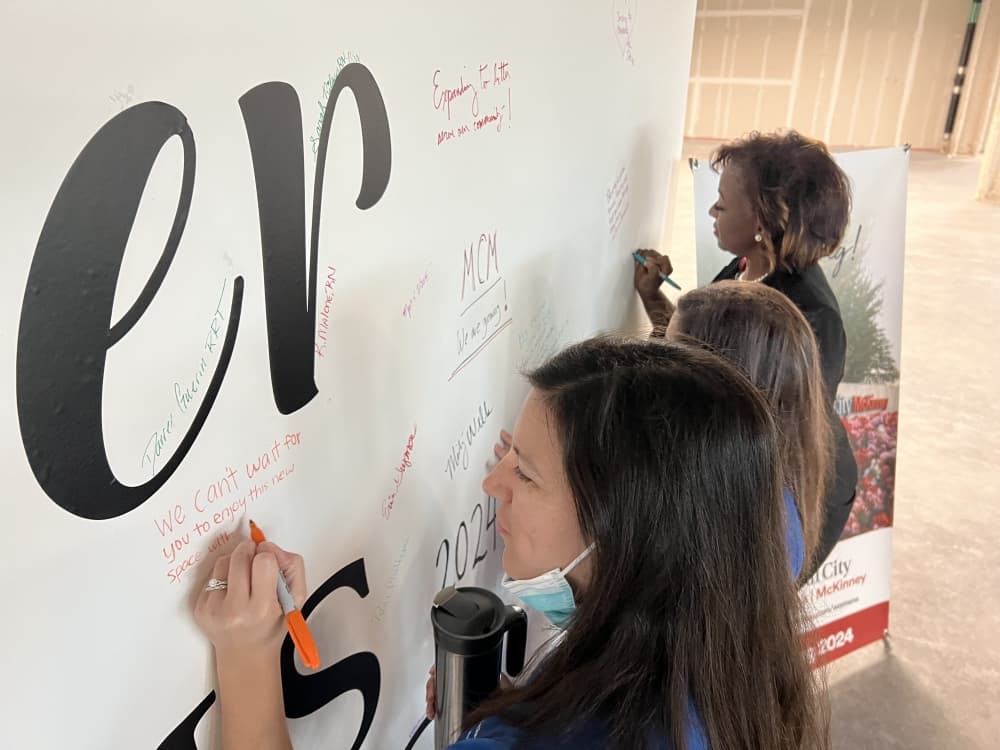 Medical City McKinney staff signing the wall at the event