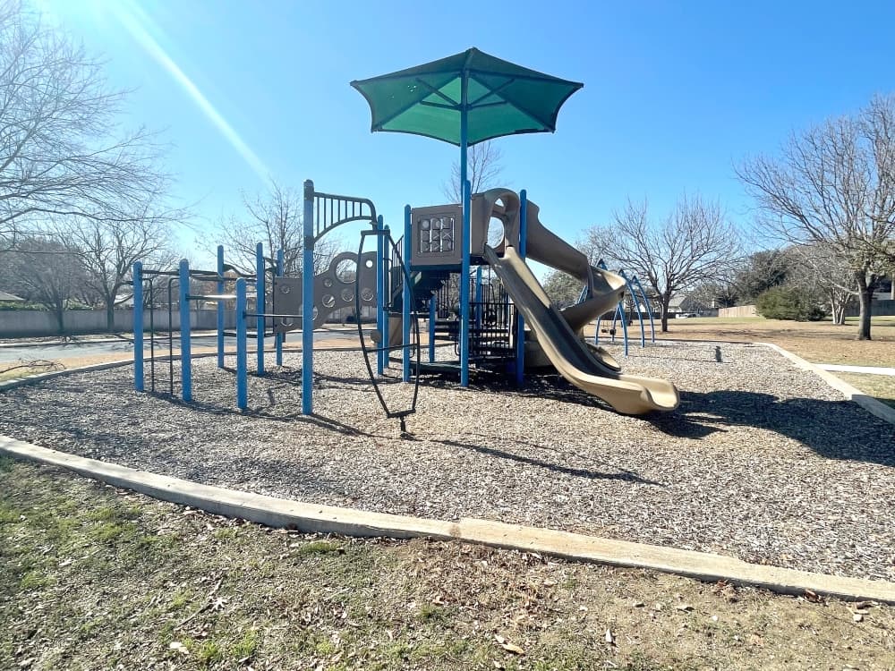 playground with slide and green umbrella