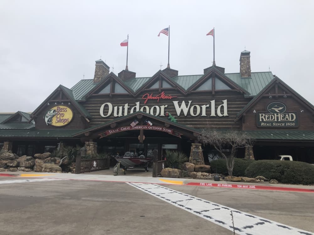 The exterior of the bass pro shop on a cloudy day. 