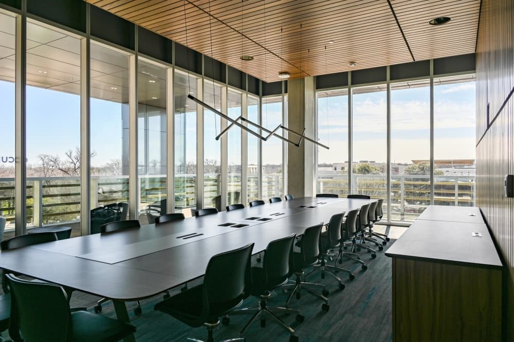 conference room with large table and multiple chairs with glass walls providing views of round rock 
