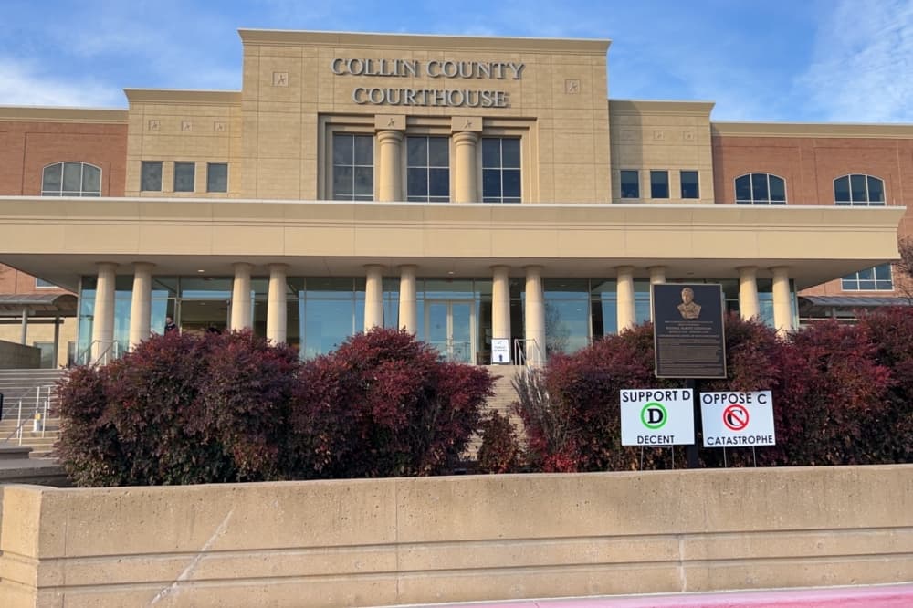 Exterior of the Collin County Courthouse with alignment support and opposition signs