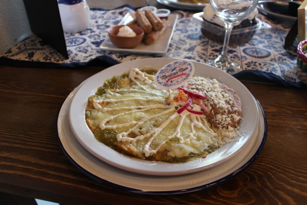 Enchiladas verdes con pollo ($14.50) are chicken enchiladas in tomatillo green sauce with beans on the side. (Kylee Haueter/Community Impact)