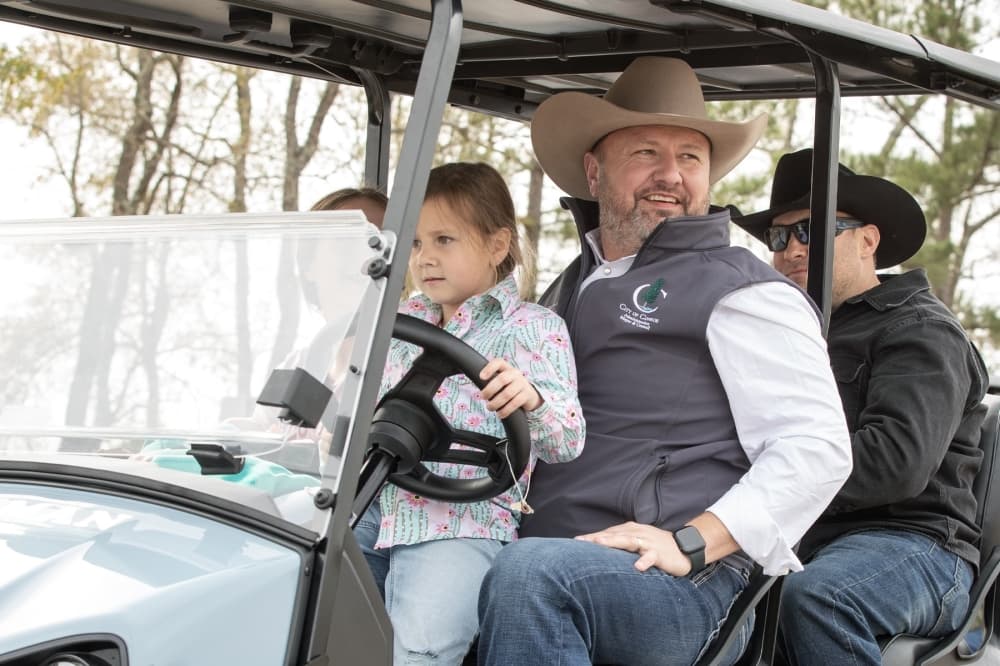 Council Member Howard Wood drives a golf cart during the Go Texan Parade. (Courtesy city of Conroe)
