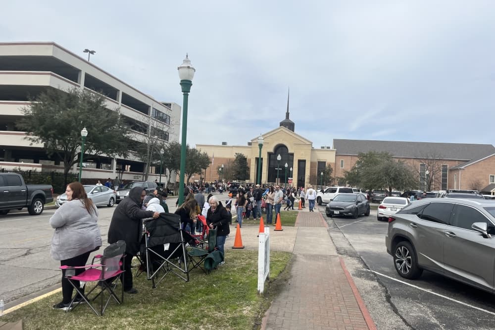 Conroe residents and visiting guests sit on the side of the road to watch the Go Texan Parade. (Peyton MacKenzie/Community Impact)
