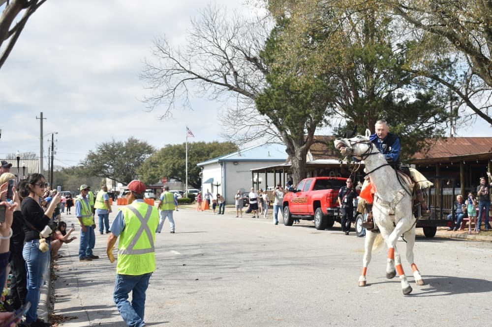 One of the Sam Houston Trail Riders spins his horse in a circle as he makes his way to the Tomball Depot Plaza. (Lizzy Spangler/Community Impact)