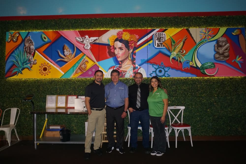 People standing in front of mural
