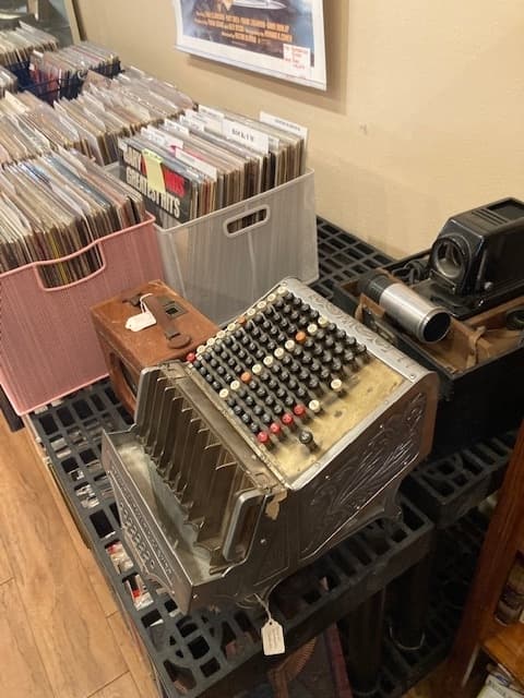 Displayed in the back room of the shop is an old-timey cash register. 