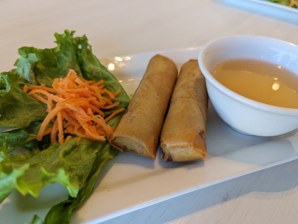 egg rolls with sauce and lettuce and carrots