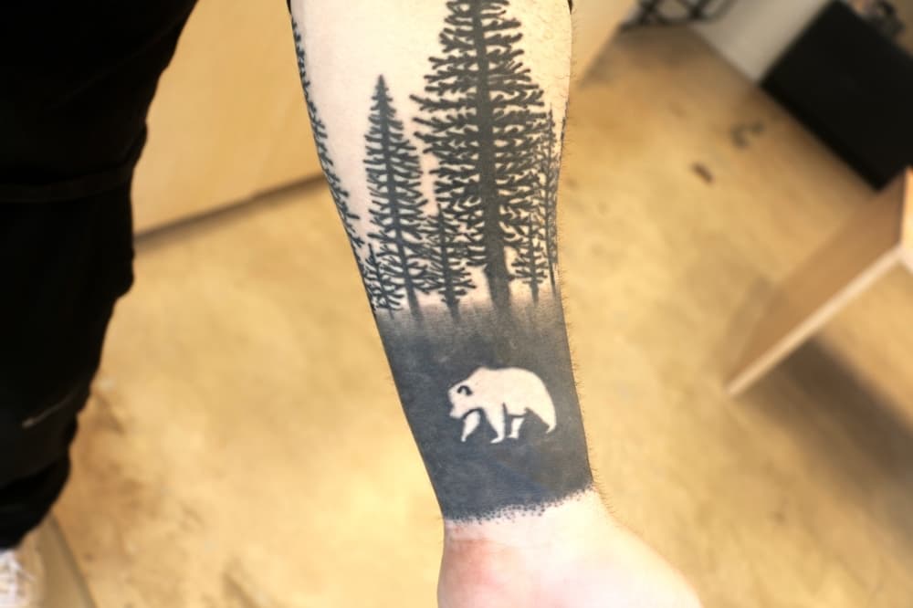 Lorin Martin's husbands tattoo is a bear and trees on his wrist