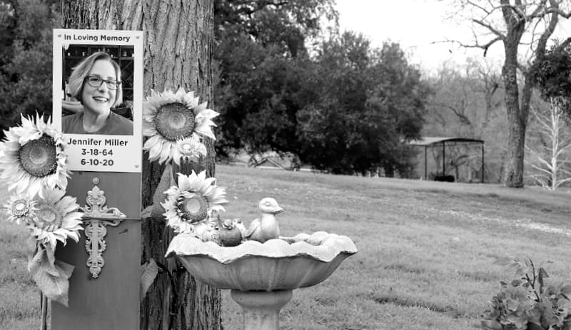 Photograph and cross next to tree.