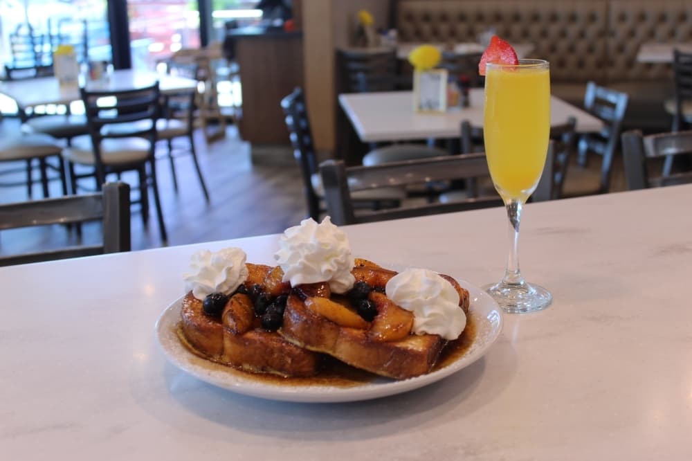 The Bourbon Flambe french toast is topped with Bourbon glazed peaches, blueberries, whipped cream and dusted with powdered sugar.
