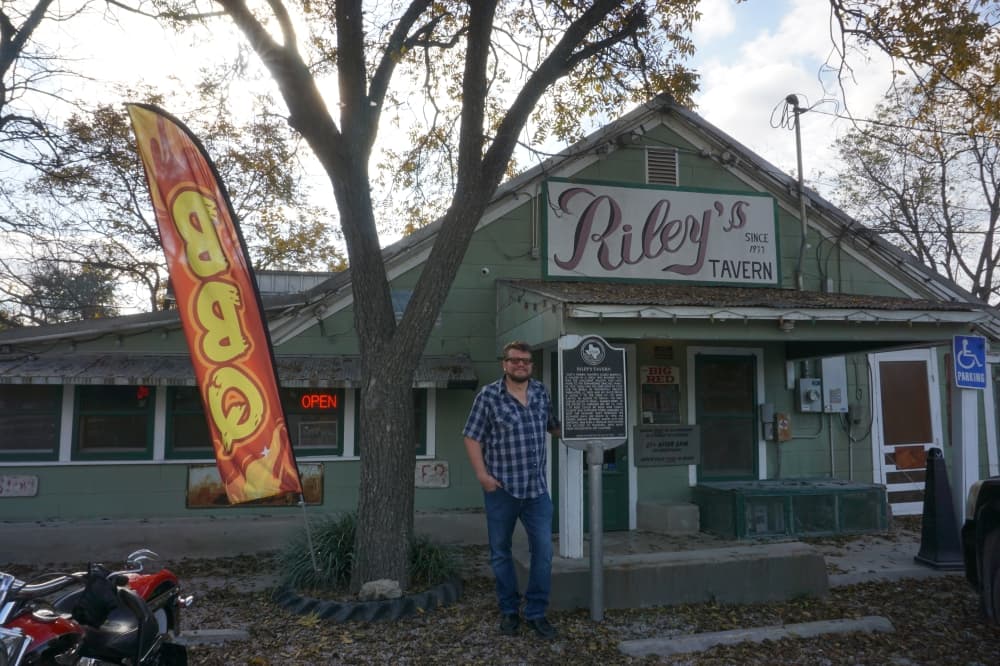 Owner of Riley's Tavern Joel Hofmann stands in front of the original structure of the bar from 1933. (Sierra Martin/Community Impact)