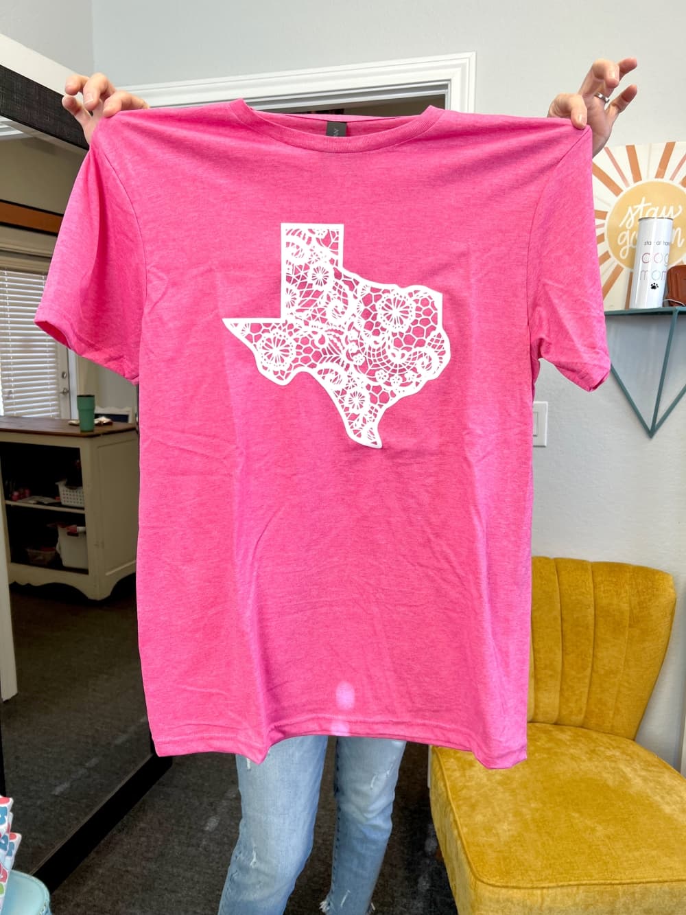 pink tshirt with white design of the shape of texas