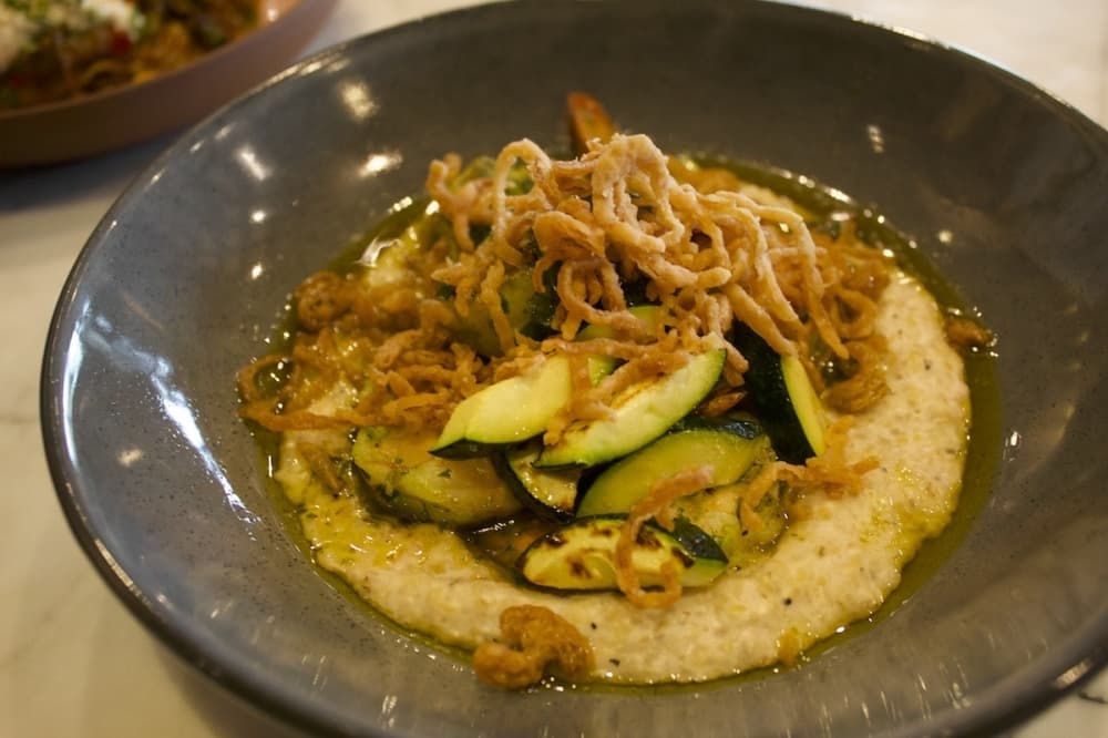 The shrimp and grits is described as an "ode to Texas" by Chef Andy Knudson and features gulf shrimp, grits, zucchini, chili crisp and shallot. $39. (Elle Bent/Community Impact)