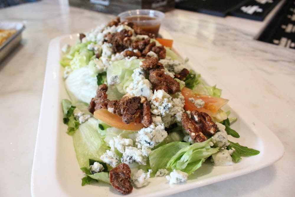 Vineyard house salad ($10.99). Candied walnuts, bleu cheese crumbles, cucumber and tomatoes served on a bed of mixed greens with raspberry vinaigrette dressing. (Emily Lincke/Community Impact)