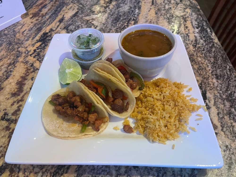 Street tacos feature pork al pastor, cilantro and onion served with rice and beans.