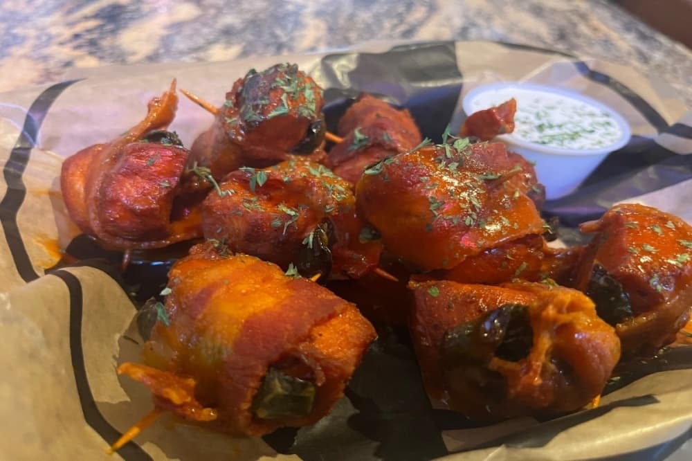 Tavern Buffalo Bites are chicken breast pieces wrapped in bacon and tossed in buffalo sauce. 