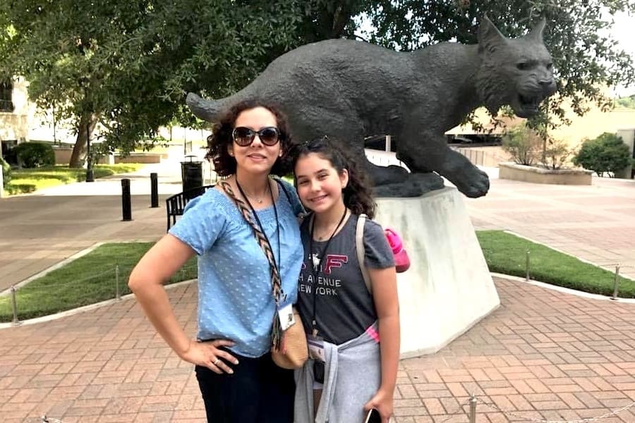 mother and daughter in front of bobcat statue