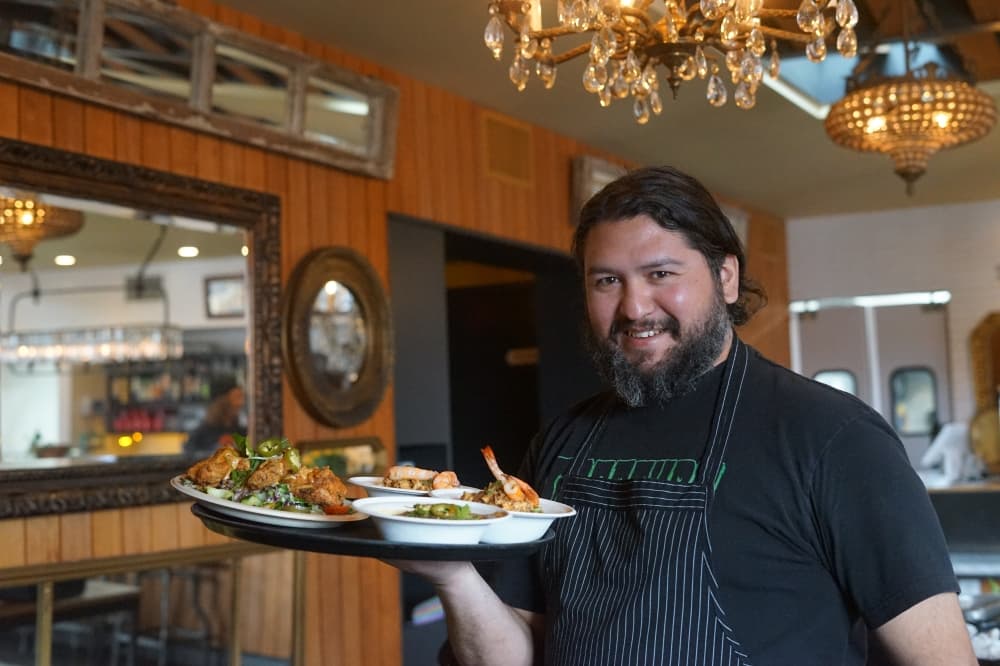 waiter smiles with tray of food 