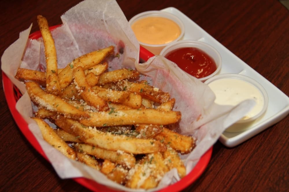 Garlic Cajun Fries ($4.25): A basket of fries is topped with garlic and an assortment of spices.