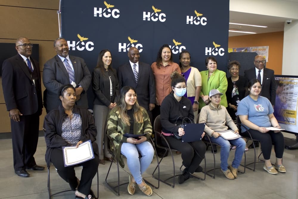 The inaugural Public Safety Telecommunicator class sits while Houston Community College faculty and staff stand behind them after a graduation ceremony March 24 (Jack Dowling/Community Impact)