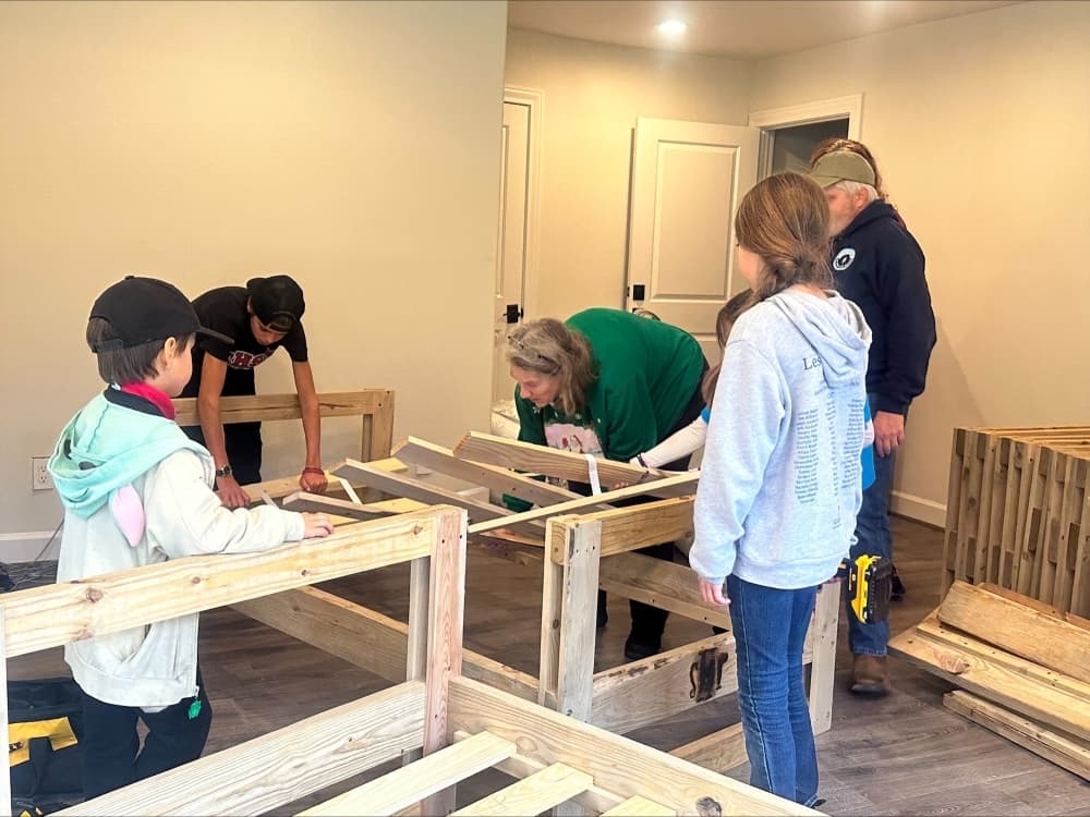 A group of volunteers puts beds together for Trel's Home for Children. (Courtesy Ken Collier)