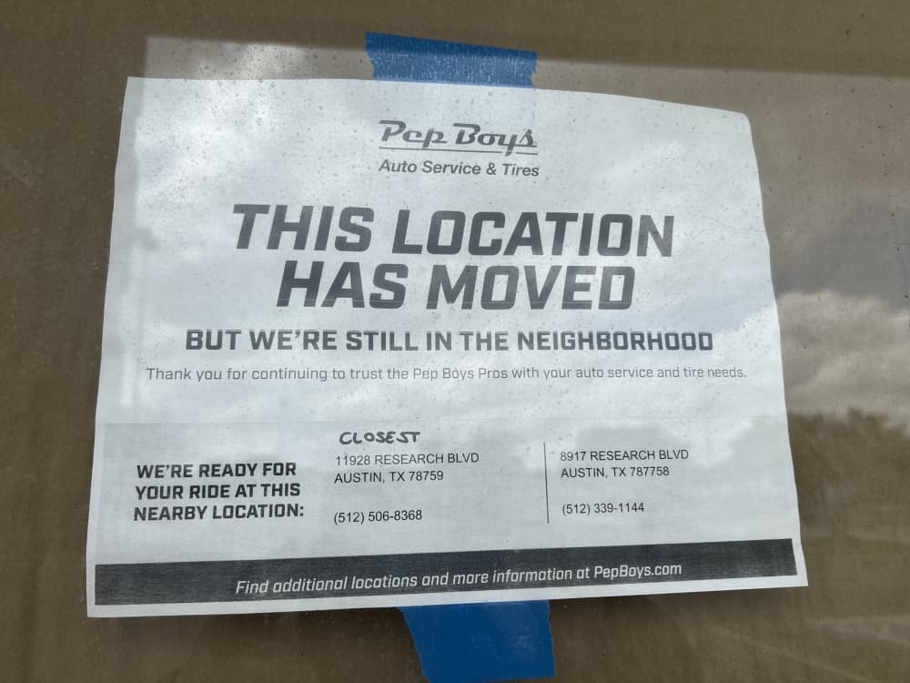 sign on door reading "this location has moved" 
