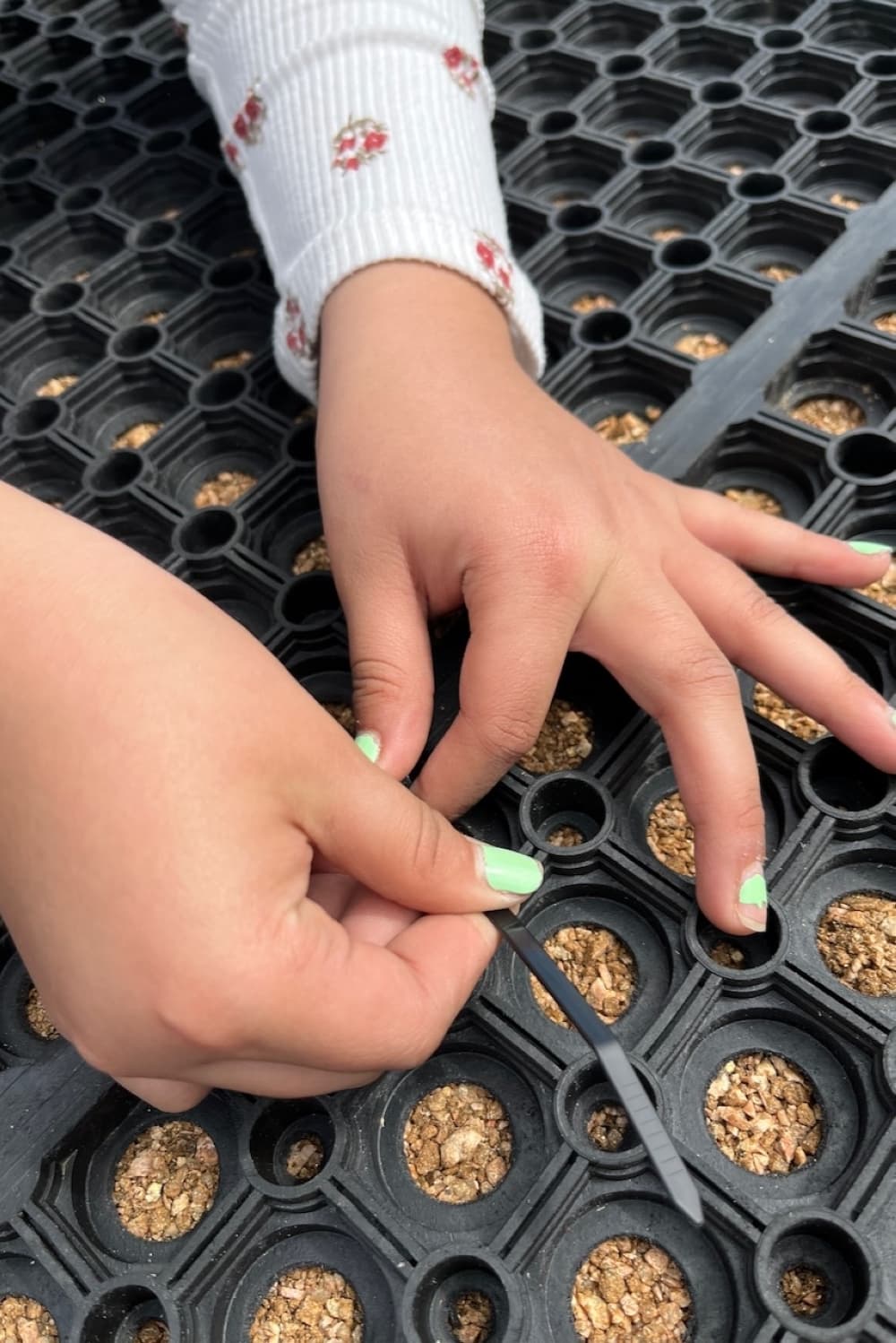 A close-up photo of one of the Girl Scout members piecing the parts together. 