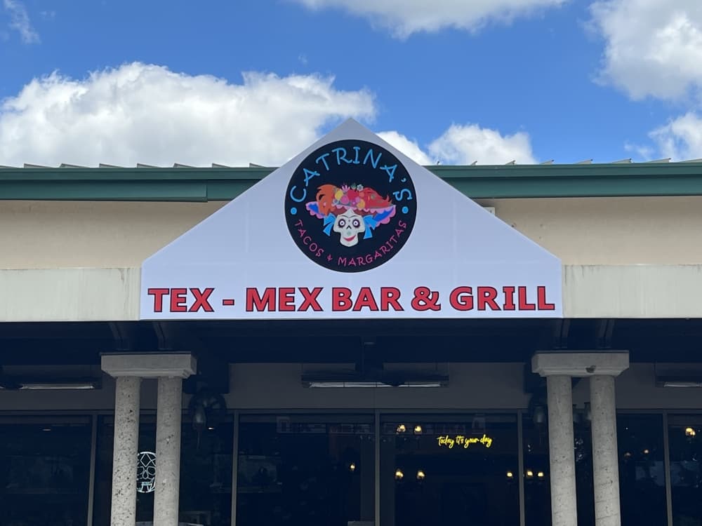 white sign with blue sky reading "Catrina's Tacos & Margaritas" and "Tex-Mex Bar & Grill" 