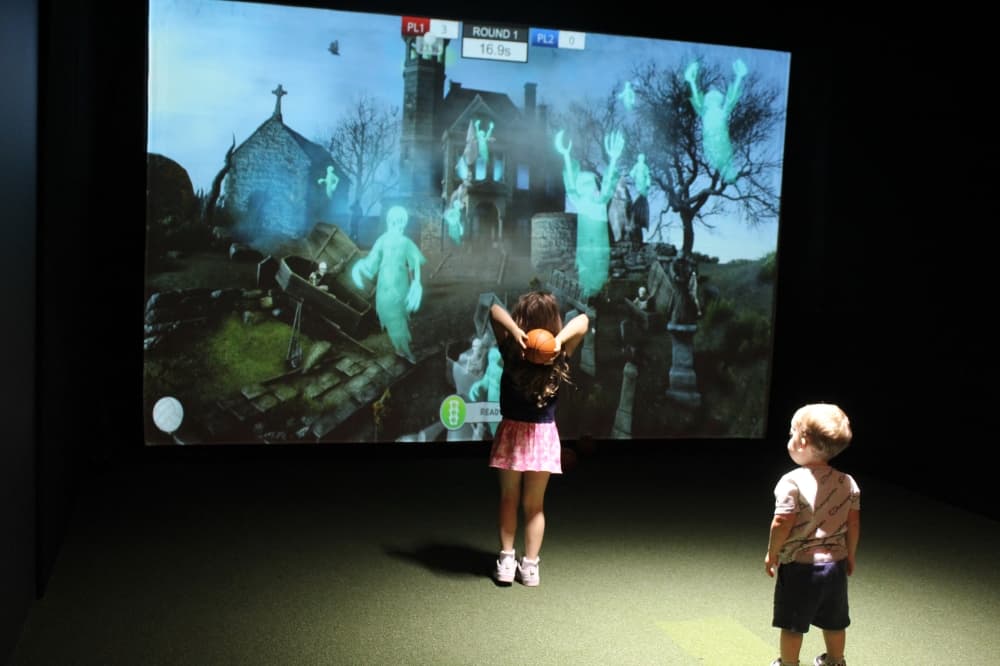Kids playing a dodgeball game on the gold simulator screen