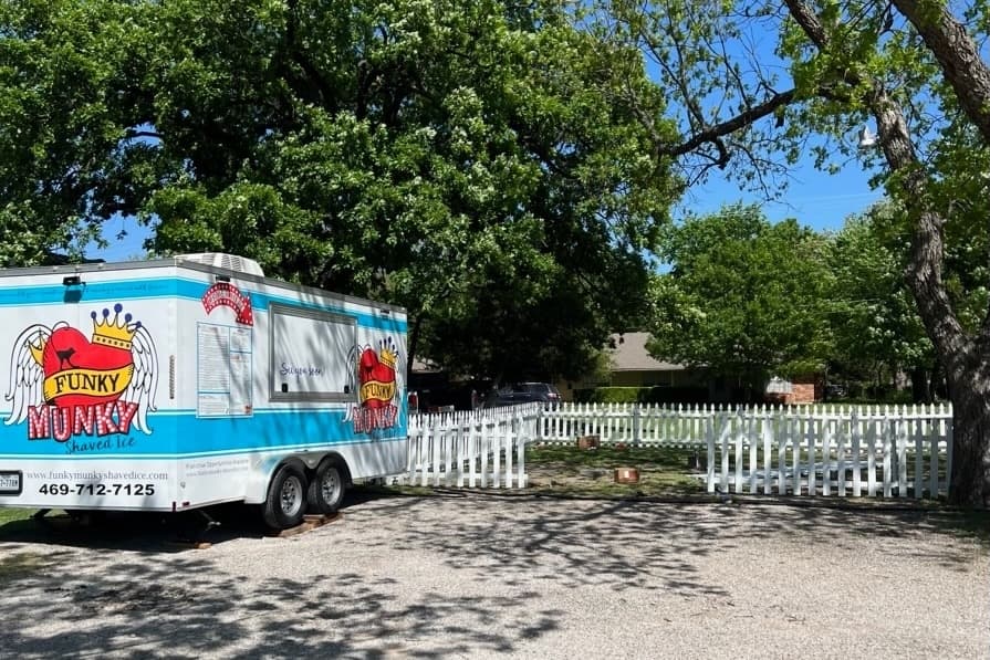 Exterior of the snow cone truck and fenced in seating area