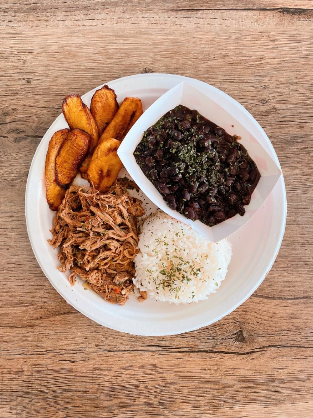 A plate of beans, rice, fried plantains and shredded beef