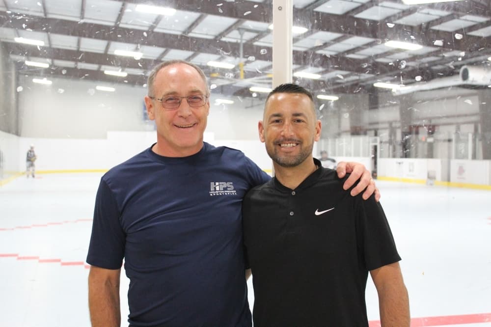 Owners standing in front of a hockey ring