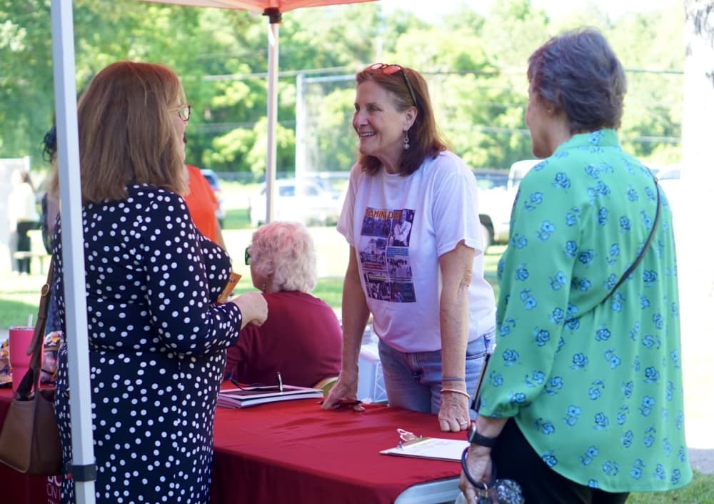 Author of "The Ground on Which I Stand: Tamina, a Freedmen's Town," Marti Corn signs copies of her book and photography at Tamina Day Celebration. 