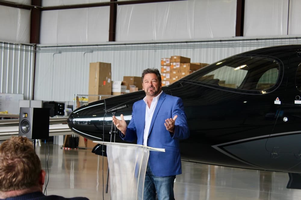 George Fuller speaking in front of a plane