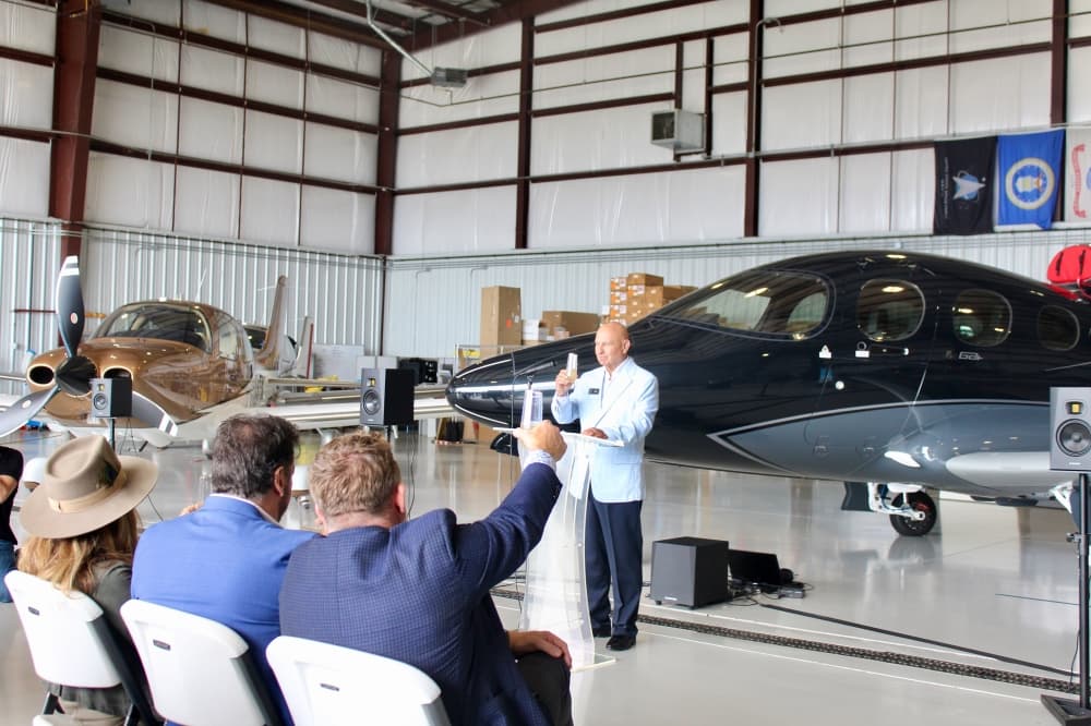 Mark Roberts speaking in front of a plane