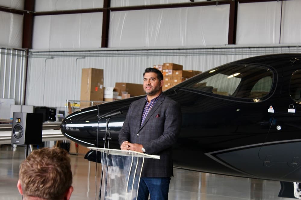 Peter Tokar speaking in front of a plane