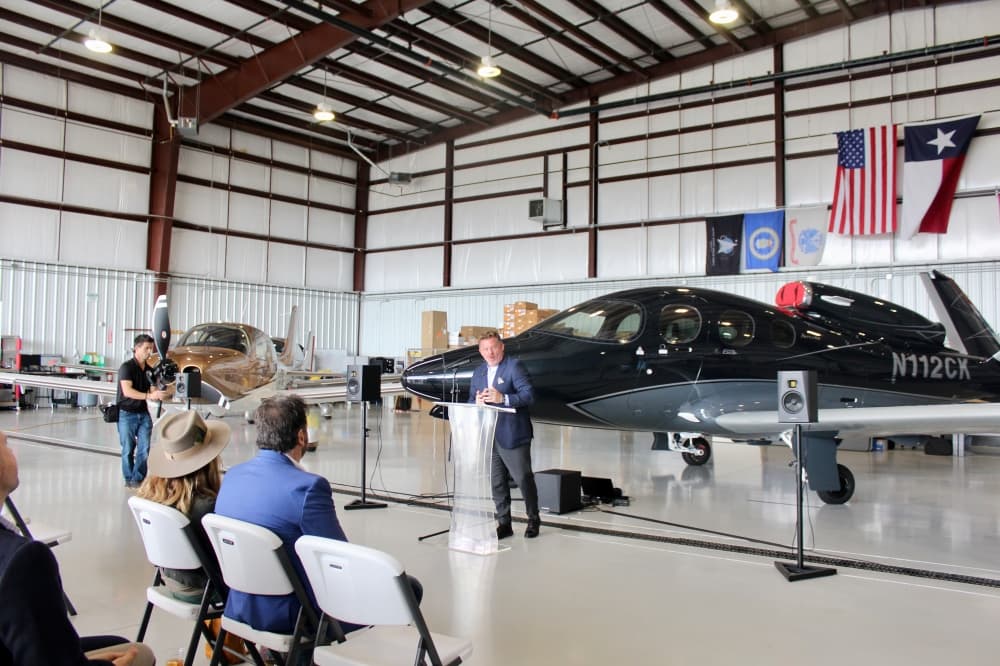 Todd Simmons speaking in front of a plane