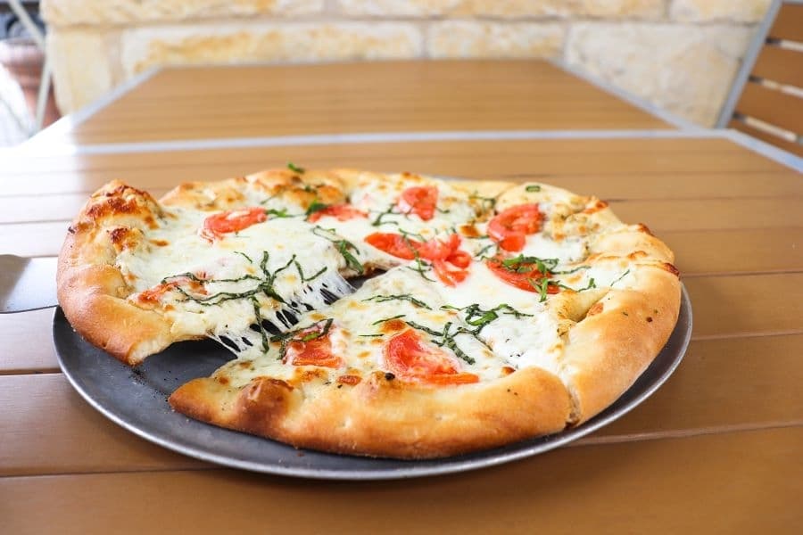 The Margherita pizza comes without tomato sauce and is topped with cheese, oil, tomato and fresh herbs. (Zara Flores/Community Impact)