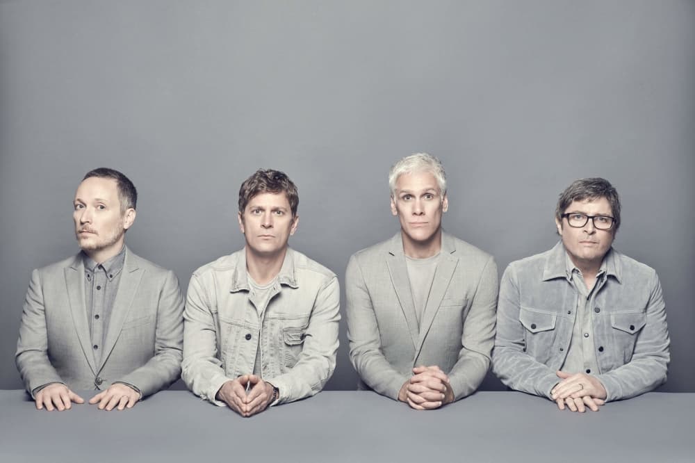 Members of Matchbox Twenty, wearing grey, are in front of a grey background.