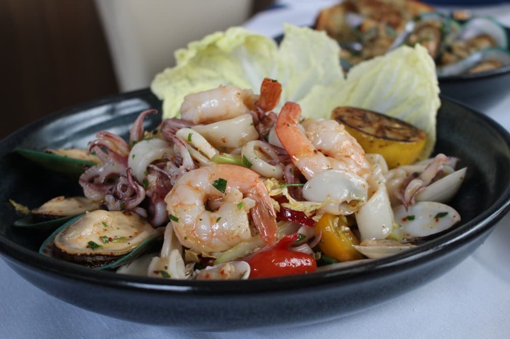Azzurro's Seafood Salad ($XX) consists of shrimp, mussels and other seafood paired with greens and a seared lemon half.