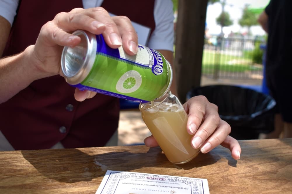 a canned beer is poured into a glass cup