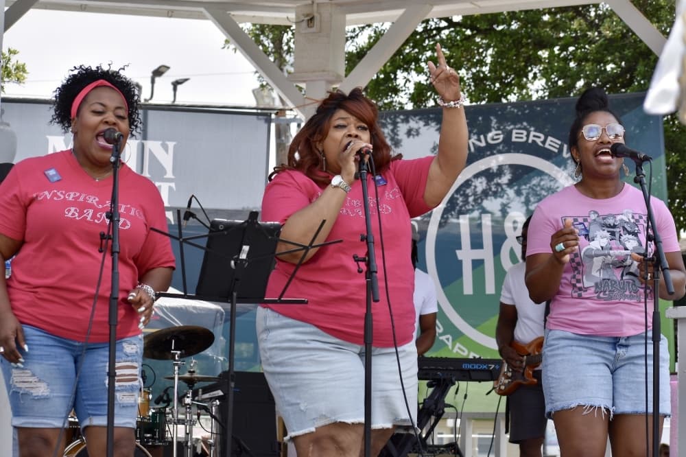 three women sing on a small stage
