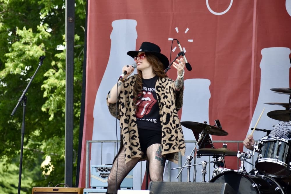 a woman in a cowboy hat sings on stage