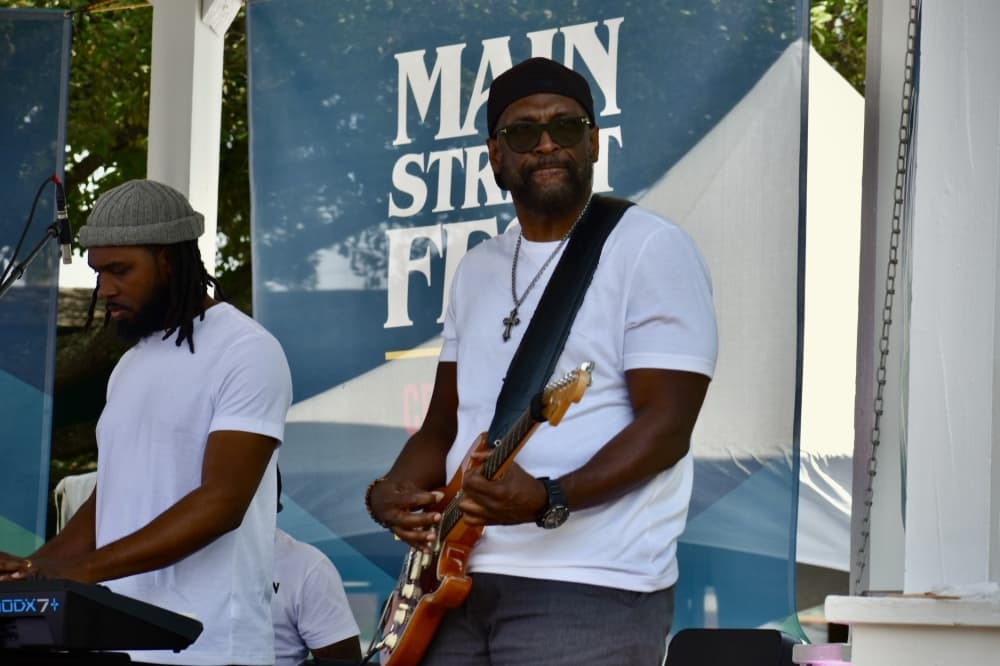 a man plays piano while another plays the guitar on stage