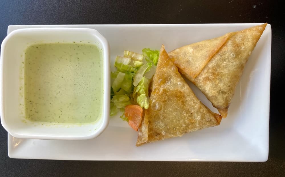 A Samosa is a fried pastry with a savory filling such as beef, chicken or vegetables.